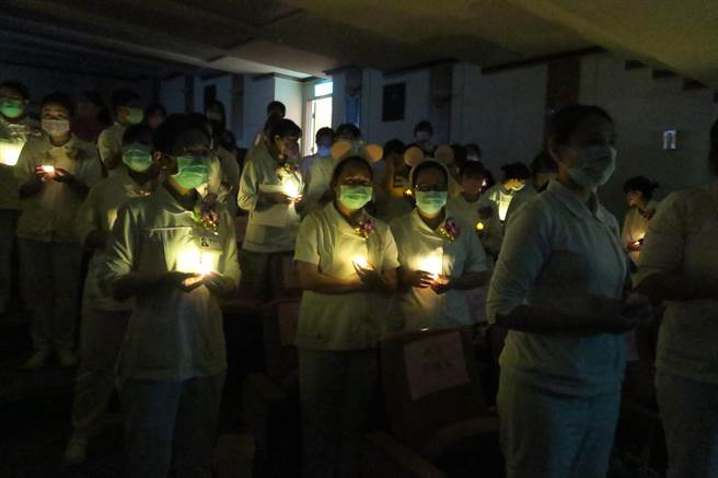 卫福部彰化医院今天举办护师节暨劳动节庆祝活动，会场内以手持烛光象徵传承南丁格尔精神。（院方提供／孙英哲彰化传真）