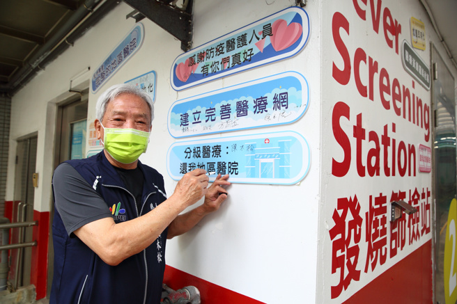 里长现场将标语贴在墙上，说出在地心声。台北市万华区、中正区近20名里长与市议员12日将「向护理师致敬」「所有防疫人员辛苦了」「我是和平人」等看板张贴在联医和平院区外，感谢医护人员无论疫情或平时对民眾的付出，同时呼吁政府将和平医院还给社区。（张铠乙摄）