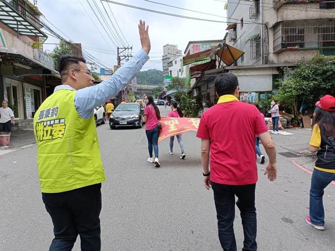 ▲将代表民进党参选立委的市议员张秉钧（左）与表态参选立委的民眾党前秘书长谢立功（右）在遶境时向民眾打招呼致意。（徐佑升摄）