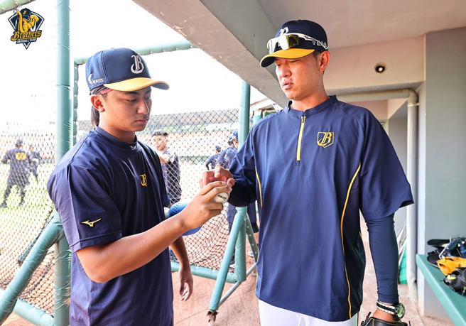 中信兄弟投手教练王建民（右）赛前指导余谦。（中信兄弟提供）