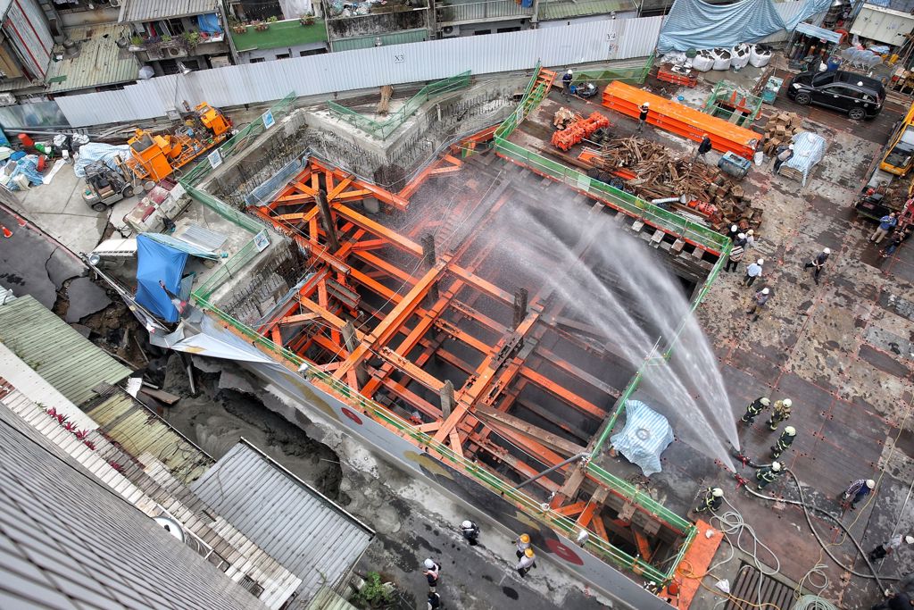 台北市信義區崇德街60巷13日驚傳地基嚴重坍塌，路面上出現巨大天坑，以致一旁住宅有倒塌危機，台北市建築管理工程處指出，此工程是因連續壁施作，已派員至現場了解處理，目前除連續壁滲水，工地正在止水中。（杜宜諳攝）