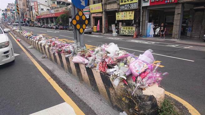 追悼车祸丧命3岁女童，民眾把鲜花与玩具放在安全岛上，不过被风吹落反增危险，女童的父亲呼吁民眾别再前往放悼念品。（程炳璋摄）