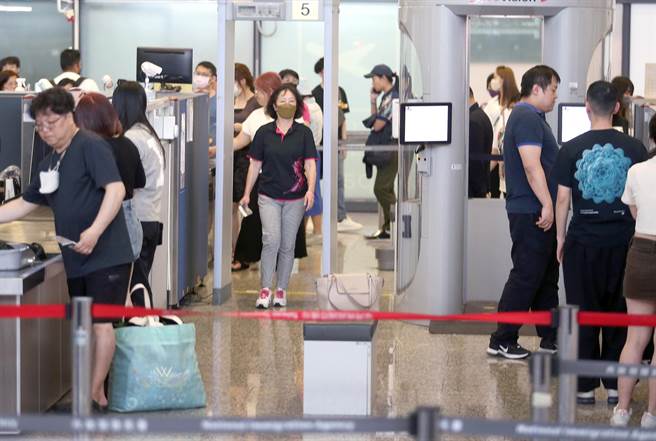 在桃园机场出境管制区内，旅客正在排队安检。（范扬光摄）