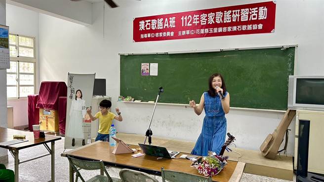花莲县政府日前邀请曾入围金曲奖「最佳客语歌手」的徐世慧（右），到南区玉里开设演唱课程教学，同为客家小歌手的国小二年级小粉丝刘尚霆（左）还在一旁伴舞，精彩演出获得满堂彩。（花莲县政府提供／罗亦晽花莲传真）