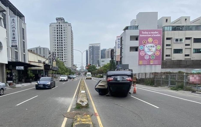 吴女驾车疑操作不慎自撞分隔岛后翻覆，整辆车四轮朝天躺在马路中。（警方提供／曹婷婷台南传真）