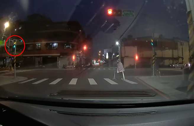 婦人拄拐杖走在斑馬線上時，不斷看著行人號誌燈秒數，深怕自己來不及通過。（翻攝自臉書爆料公社）