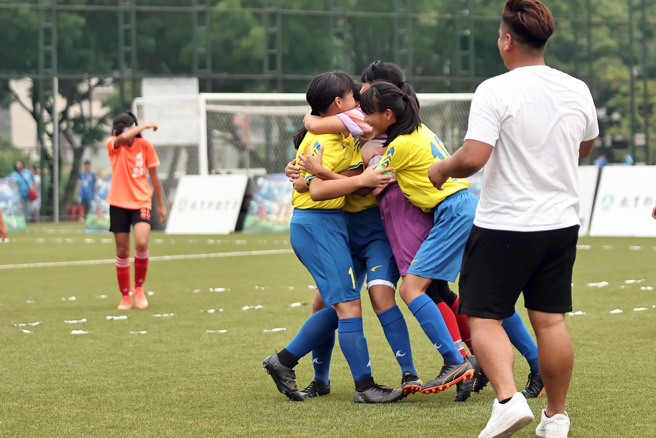 111学年度国小世界杯女子组冠军赛，花莲东里国小获胜后全队激情相拥。（迷你足球协会提供）