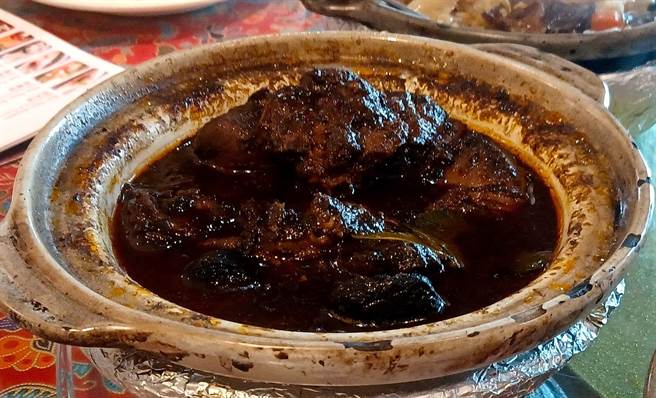 「黑果鸡」是在台湾吃不到的特色料理，以鸡肉搭黑果炖煮，再加入辛香料调味，咸甜交织很唰嘴。(陈韵萍摄)