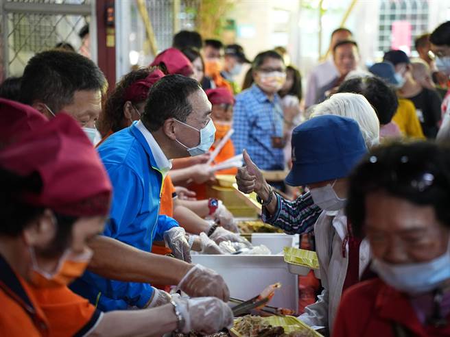 侯友宜最后在现场加入老人共餐的志工，一同替长者打菜、互动，时不时也有来共参长者对他竖起大拇指表达肯定。(黄敬文摄)