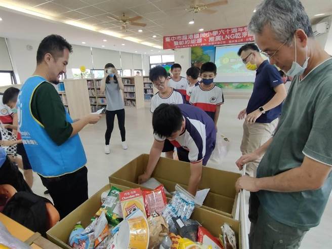 台中龙井区龙港国小学生16日踊跃响应食物传爱活动，不一会儿就装满了食物银行人员带来的两大箱纸箱。（潘虹恩摄）