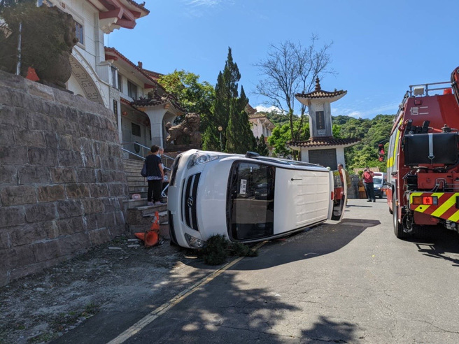 李男驾驶白色箱型车搭载7名乘客，行经事故地点时，不慎自撞路缘及路旁停放之黑色箱型车后朝左侧翻，其中2名女性乘客轻微擦挫伤，由救护人员送至基隆长庚医院就医。（图／警方提供）