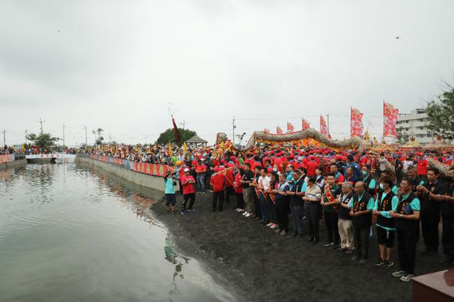 嘉义县布袋镇新塭嘉应庙举办「衝水路、迎客王」祭典，来自全国的信眾和宫庙塞爆王船码头。(嘉义县民政处提供)