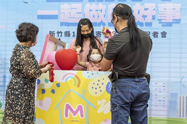 李秉伦（右）、王昱乔（左）夫妇打开礼物，曾受照顾的5岁小女孩和生母现身。（罗浚滨摄）