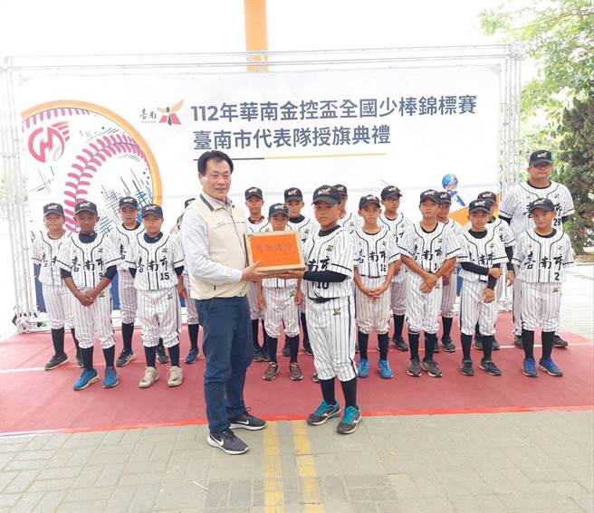 台南市政府体育局长陈良乾（左）今天为华南金控杯全国少棒锦标赛台南代表队授旗。（台南市体育局提供／曹婷婷台南传真）