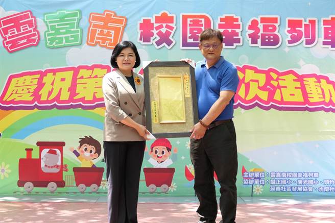「云嘉南校园幸福列车」第100场抵达云林县水林乡，县长张丽善（左）赠匾额给列车长翁荣辉（右）。（张朝欣摄）