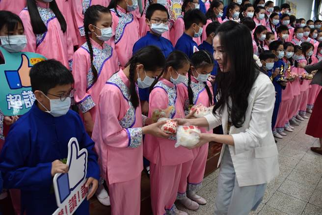 苗栗县长夫人陈美琦18日上午赴头份市建国国小替合唱团加油打气，亲送小朋友自购的好吃大肉包。（谢明俊摄）
