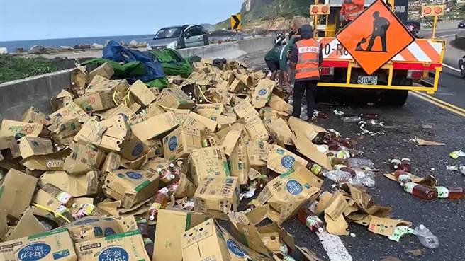 新北市瑞芳区水湳洞路段的台2线滨海公路发生联结车货物未綑扎确实，导致饮料散落路面。（翻摄画面／张志康新北传真）