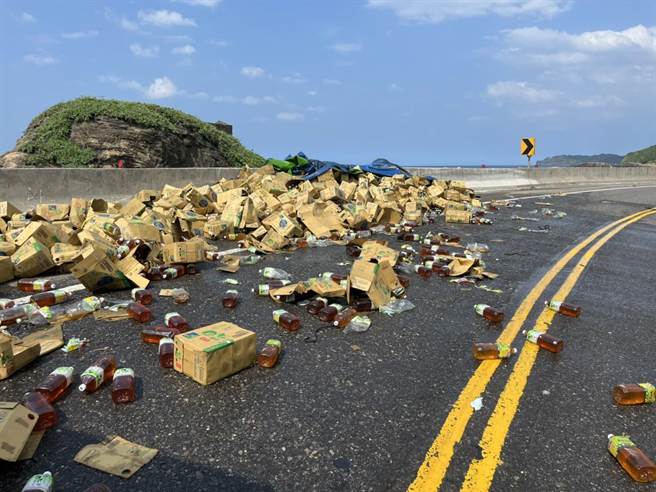 新北市瑞芳区水湳洞路段的台2线滨海公路发生联结车货物未綑扎确实，导致饮料散落路面。（翻摄画面／张志康新北传真）