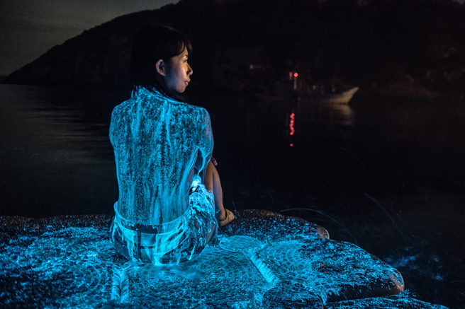 马祖近日蓝眼泪大量爆发，北竿追泪达人周治孝更拍到游客身体披上蓝光画面，他说，这张照片没有修图，是藉泼海水在游客身上而拍出的效果。（「马祖有个周小马 追泪人」提供）中央社记者高华谦传真