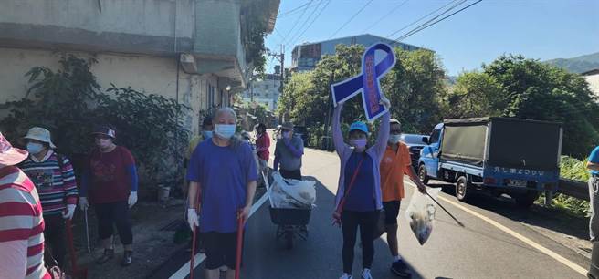 吉庆社区理事长陈新美结合清洁车收垃圾进行社区防暴宣导，志工还帮忙做清扫。（新北市社会局提供）