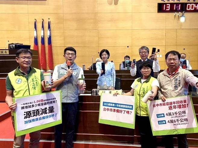 台中市议会19日警消环卫质询，市议员黄守达、谢志忠、张玉嬿、王立任送环保杯给副市长王育敏以及环保局长陈宏益，要求市府重视垃圾源头减量政策。（张亦惠摄）