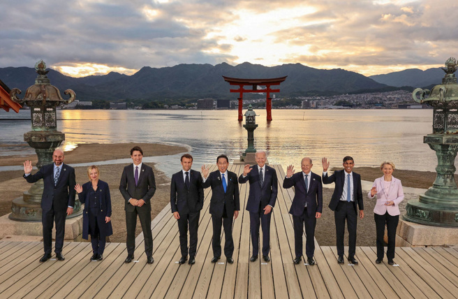 G7峰会与会领袖19日傍晚在日本广岛县海边的神社合影。左起欧洲理事会主席米歇尔、义大利总理梅洛尼、加拿大总理杜鲁道、法国总统马克宏、日相岸田、美国总统拜登、德国总理萧兹、英相苏纳克、欧盟执委会主席范德赖恩。（路透）