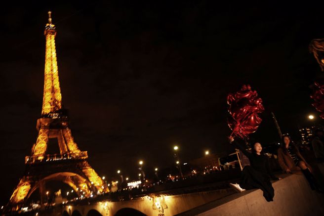 图中一名中国游客在巴黎艾菲尔塔前拍照。欧洲各热门观光景点至今未盼来大量中国游客，观光业者群起向政府施压要求对中国实施更多开放措施。（图／路透）