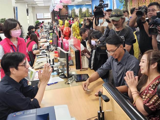 市长陈其迈化身一日户政员，协助新人办理结婚登记，递上已登记完成的身份证，并送上相框祝福新人。（林雅惠摄）
