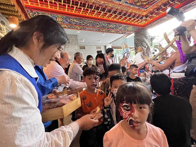 开幕式有祈福仪式，参与民眾钻过八家将后，主办单位准备祈福饼乾共享。(蔡依珍摄)