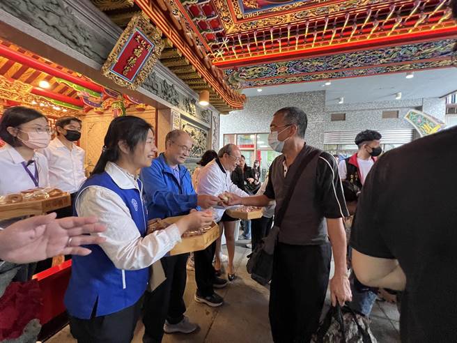 开幕式有祈福仪式，参与民眾钻过八家将后，主办单位准备祈福饼乾共享。(蔡依珍摄)