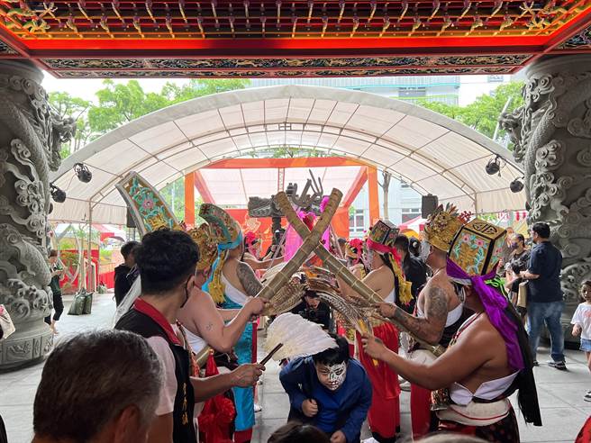 开幕式有祈福仪式，参与民眾钻过八家将后，主办单位准备祈福饼乾共享。(蔡依珍摄)