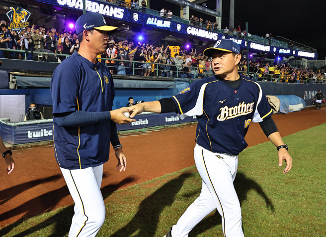 中信兄弟總教練彭政閔（右）將「接力無安打」比賽勝利球送給投手教練王建民。（中信兄弟提供）