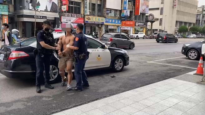 警方稍早将朱男从警车上压解下车，双手戴上手铐及脚镣，由2名员警押解进警局画面曝光。（翻摄画面）