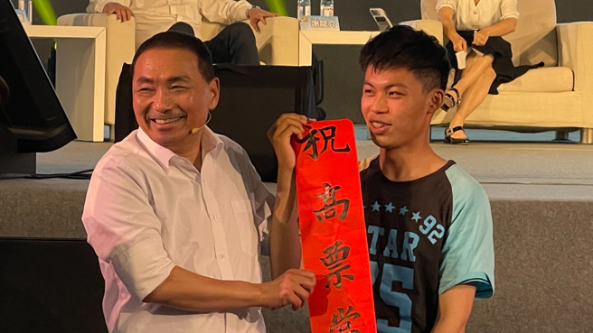 该名澎湖男大生更带来了自己亲手写的毛笔字，有着「祝高票当选」的红布条要送给侯友宜。（读者提供）