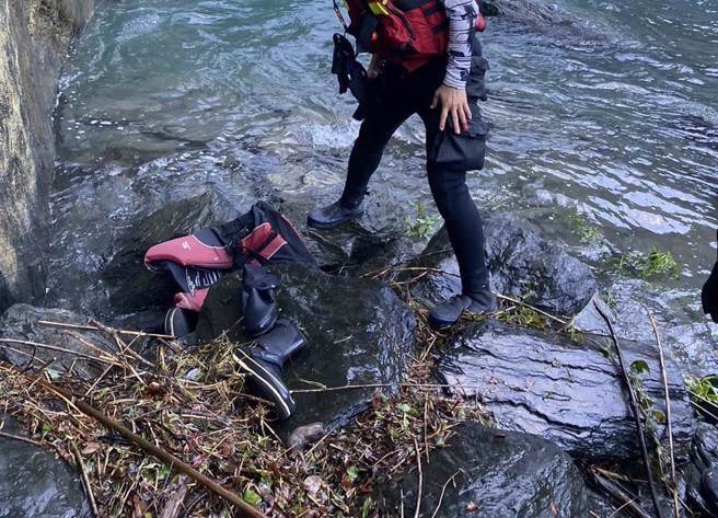 屏东雾台乡飞龙瀑布20日发生10人因溪水暴涨受困，当中5人由直升机平安吊挂获救，21日下午3时许，搜救人员于上午寻获的装备下方寻获1具遗体。（屏东消防局提供／谢佳潾屏东传真）