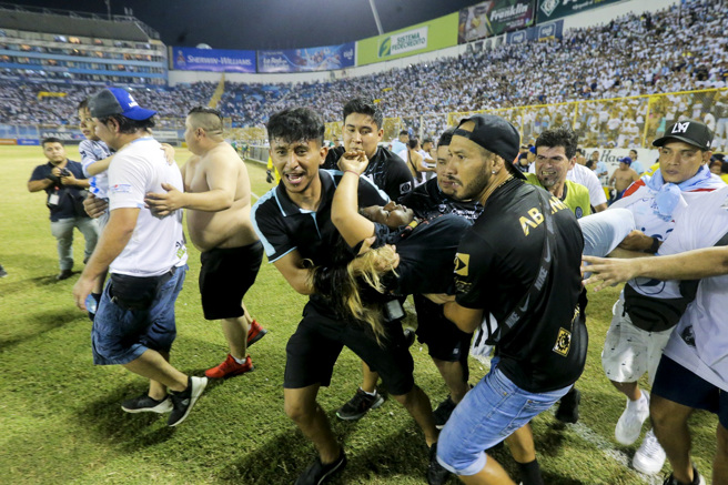 中美洲国家萨尔瓦多20日晚间的足球赛演变成严重踩踏事件。图为一名女球迷被抬到场中央治疗。（图／美联社）