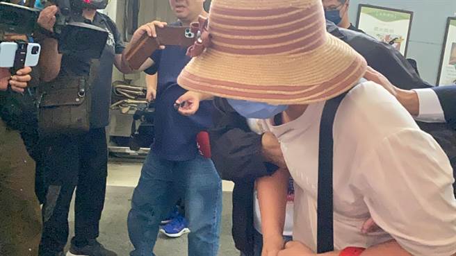 赖母步出冰柜时满脸哀悽，腿软无力需由旁人搀扶。（冯惠宜摄）