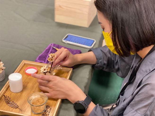 伃姗以木皮制作成精致的花朵饰品相当受到顾客喜爱。(中彰投分署提供)