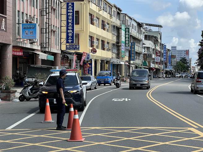 高雄市冈山区大义二路22日上午发生车祸，警方到场维护交通，当地民眾质疑道路设计不良导致车祸连连。（林瑞益摄）