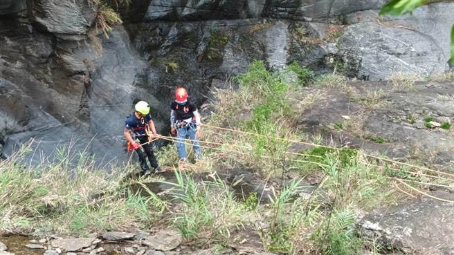 警消将吊挂岩壁死者移往平地，等待直升机吊挂。(屏县消防局提供)