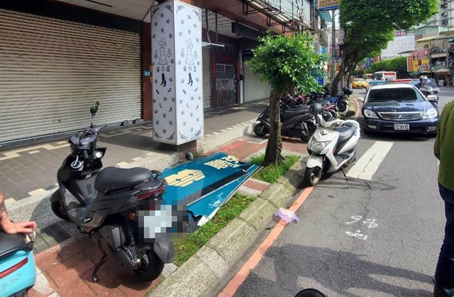 招牌掉落砸中机车，机车翻覆压伤妇人。（警方提供）