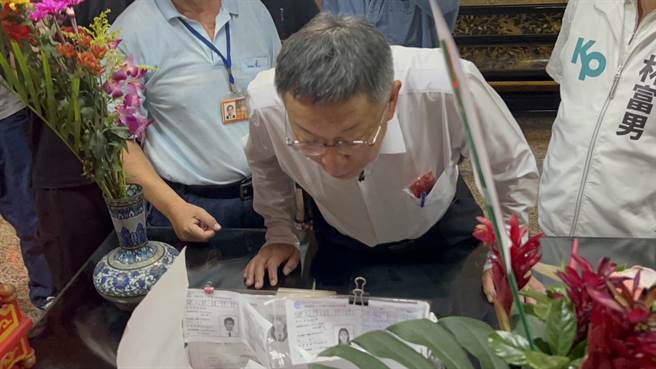 柯文哲参拜文昌帝君时，发现有会考生祈福用的准考证影本，仔细观察一番。（崔正纲摄）