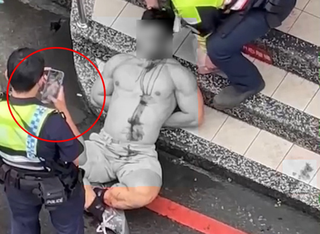 朱姓男子20日大闹中坜区一间超商遭到警方制伏在地，但值勤员警遭激怒，持警棍殴打朱男12下引发外界争议，如今有网友点出警方事后拿出手机拍照。（图／记者爆料网@荿仔提供）