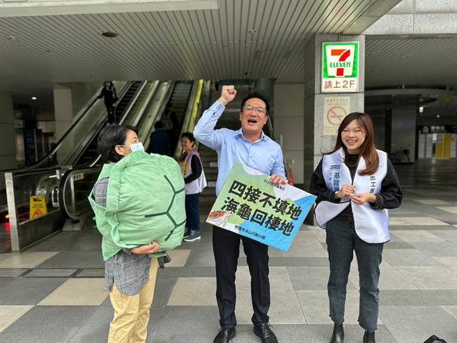 公民团体守护外木山行动小组23日一早在基隆火车站举牌，呼吁市民共同关心25日将举行的四接环评会议。（守护外木山行动小组提供／张志康基隆传真）