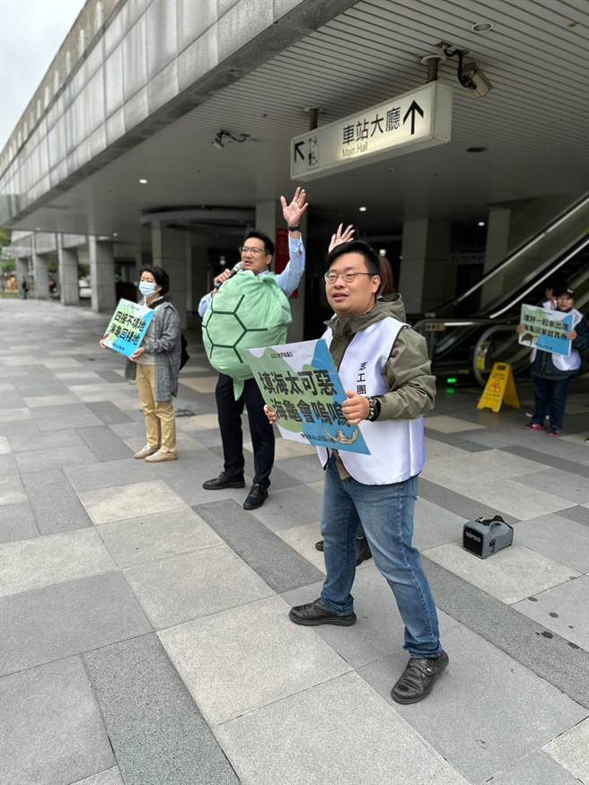 公民团体守护外木山行动小组23日一早在基隆火车站举牌，呼吁市民共同关心25日将举行的四接环评会议。（守护外木山行动小组提供／张志康基隆传真）