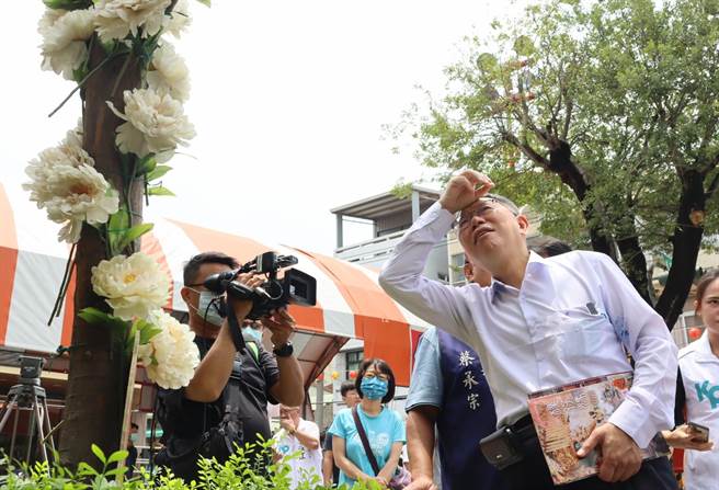 民眾党主席、总统参选人柯文哲认真聆听庙方人员解说求子红白花歷史。（吕妍庭摄）