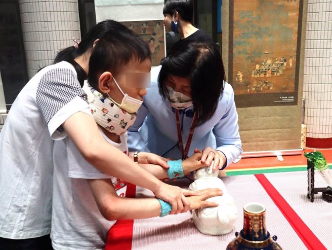 国立故宫博物院与台中市私立惠明盲校23日至25日合作举办「跨越障碍．触摸美丽－故宫之美 eye在惠明」，志工带领身心障碍学生触摸故宫文物近距离感受作品的美并认识故宫文物。（潘虹恩摄）
