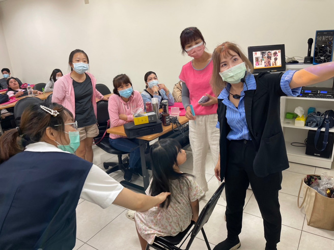 新住民姐妹认真听讲师解说造型设计应搭配脸型、头型、髮质及服装。(戴志扬翻摄)
