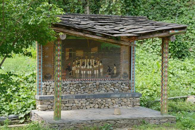 信义乡双龙桥候车亭以石板屋意象，搭配工艺家米万吉木雕作品「八部合音」，充满布农风情，该候车亭一度因落石毁损，2020年已修復。（本报资料照片／杨静茹南投传真）