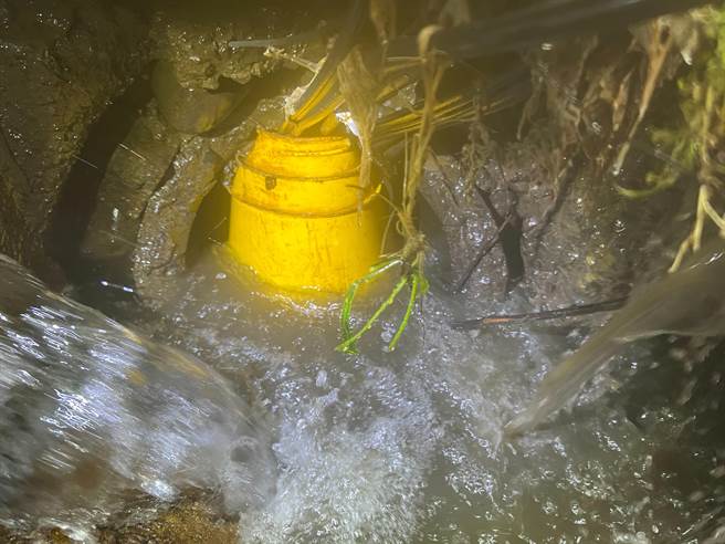 桃园龟山华亚三路、振兴路口10日有水不断流出造成淹水，水务局表示，是放流水管线被石头、水桶堵塞，经排除后已经改善。（桃园市水务局提供）